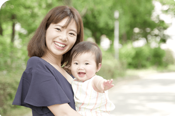 笑顔で赤ちゃんを抱える女性のお客様