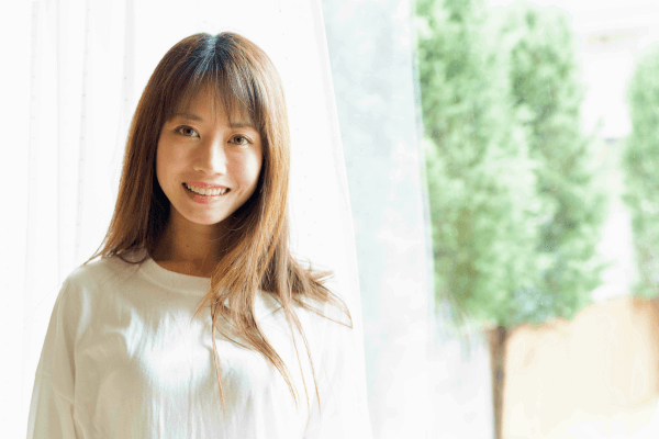 明るい窓辺で微笑む女性のお客様